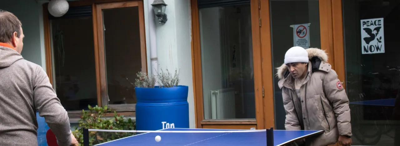 Twee mannen spelen buiten een potje tafeltennis